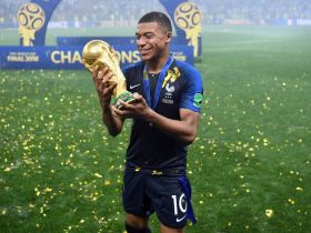 France forward Kylian Mbappe celebrates with the World Cup trophy. © Witters Sport-USA TODAY Sports