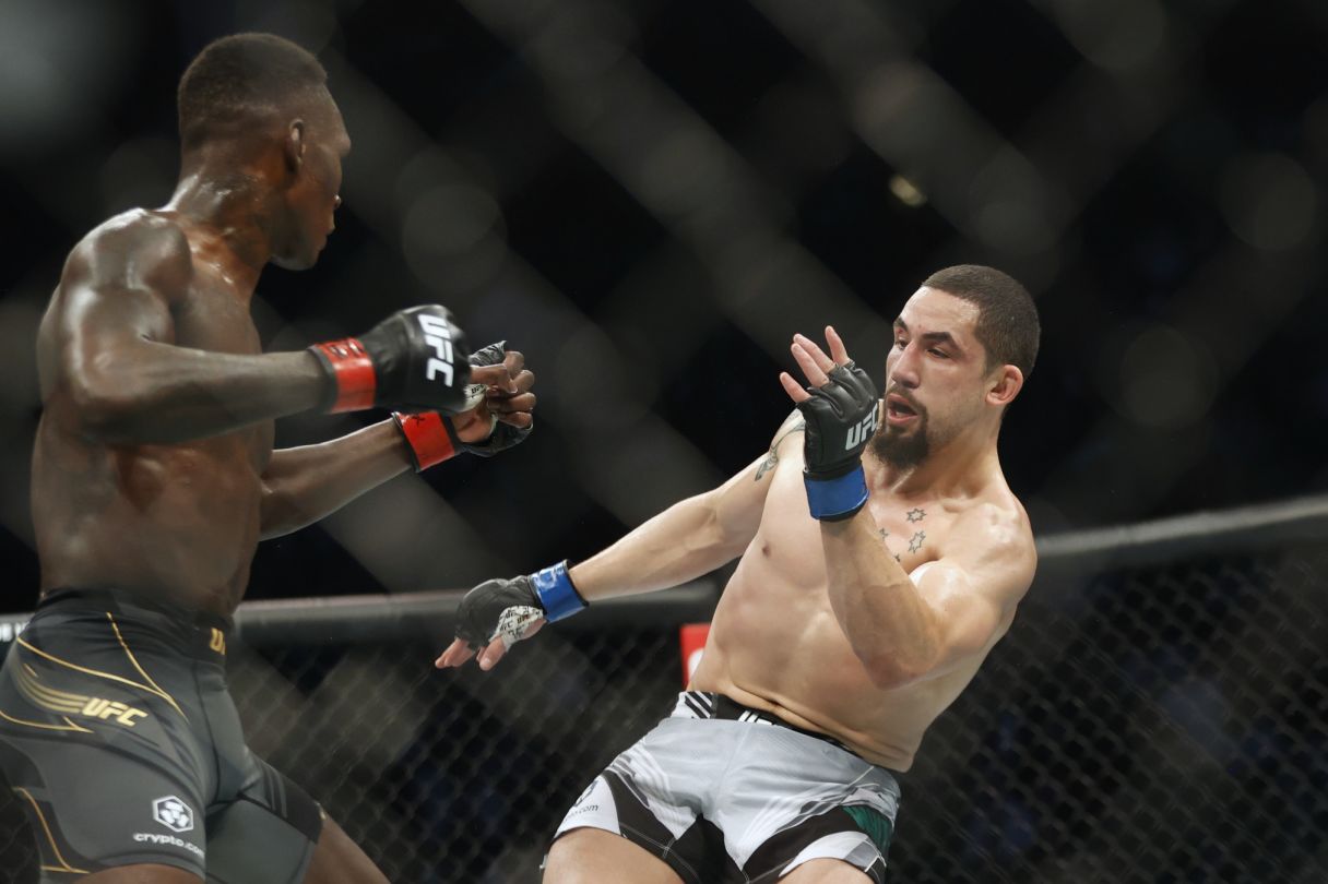 Israel Adesanya cracks Robert Whittaker with a left hand as he retreats