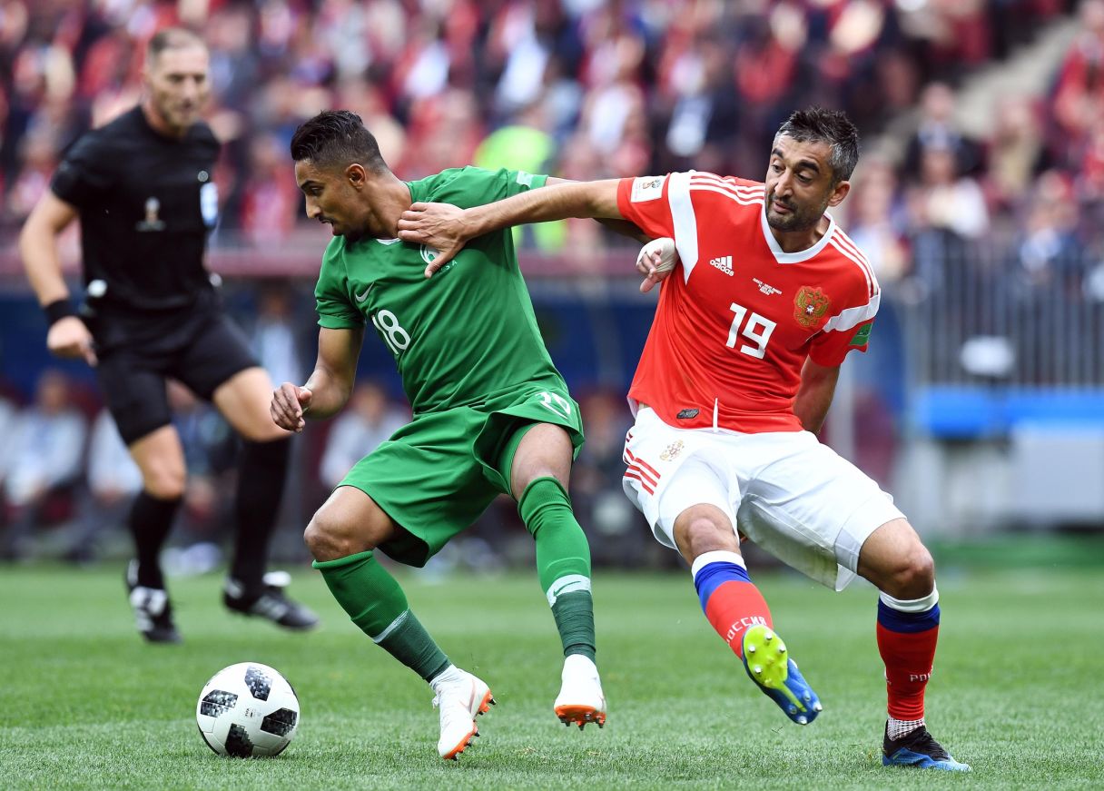 Saudi Arabia midfielder Salem Al-Dawsari (18) chases the ball with Russia midfielder Aleksandr Samedov (19)