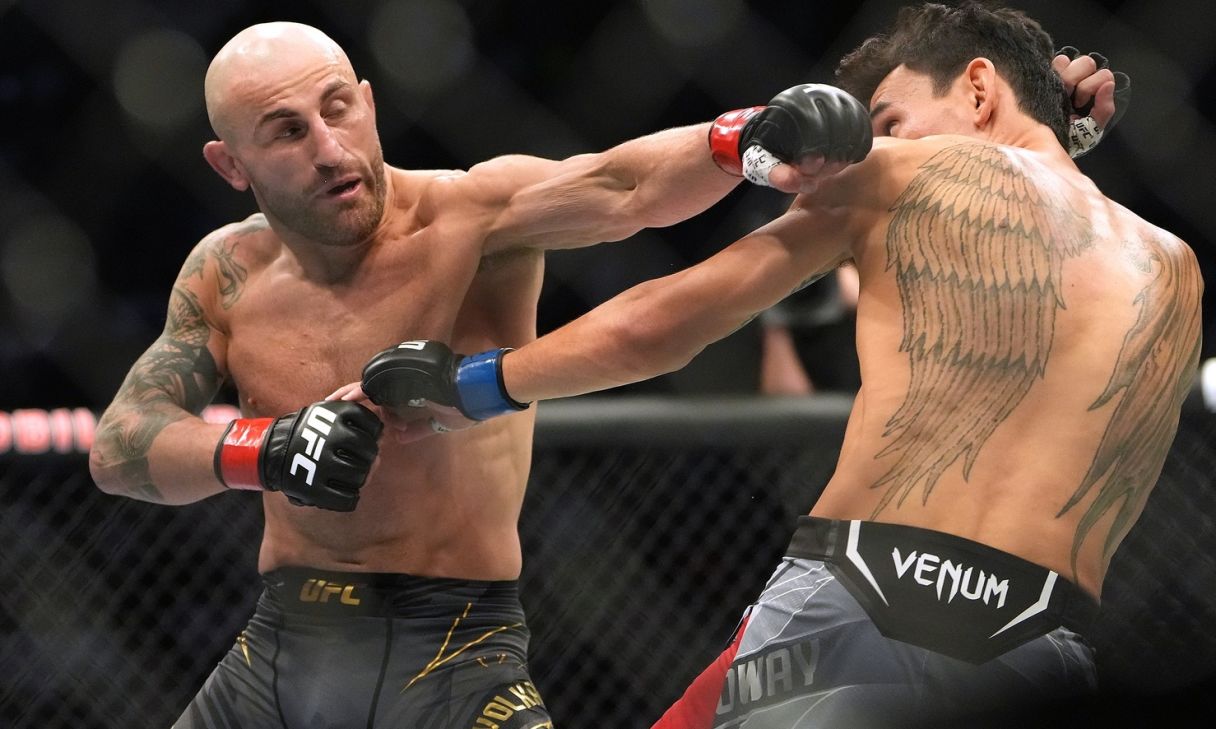 Alexander Volkanovski (red gloves) and Max Holloway (blue gloves) fight in a bout during UFC 276 at T-Mobile Arena. Mandatory Credit: Stephen R. Sylvanie-USA TODAY Sports