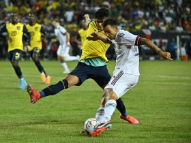 Mexican National Team midfielder Luis Chavez (27) launches a shot toward the goal as Ecuador National Team defender Xavier Arreaga (14) lunges to defend in the second half at Soldier Field. Mandatory Credit: Jamie Sabau-USA TODAY Sports