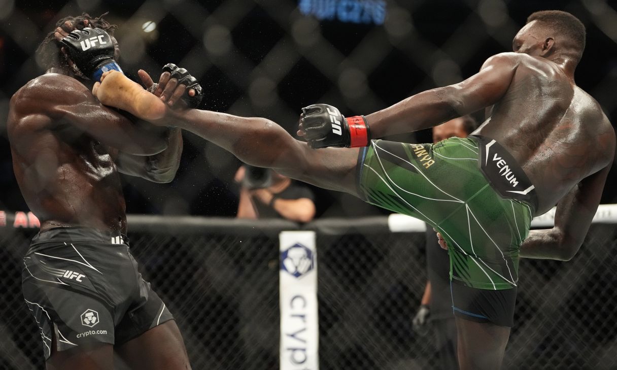 Israel Adesanya attempts a kick on Jared Cannonier (blue gloves) in a bout during UFC 276 at T-Mobile Arena. Mandatory Credit: Stephen R. Sylvanie-USA TODAY Sports